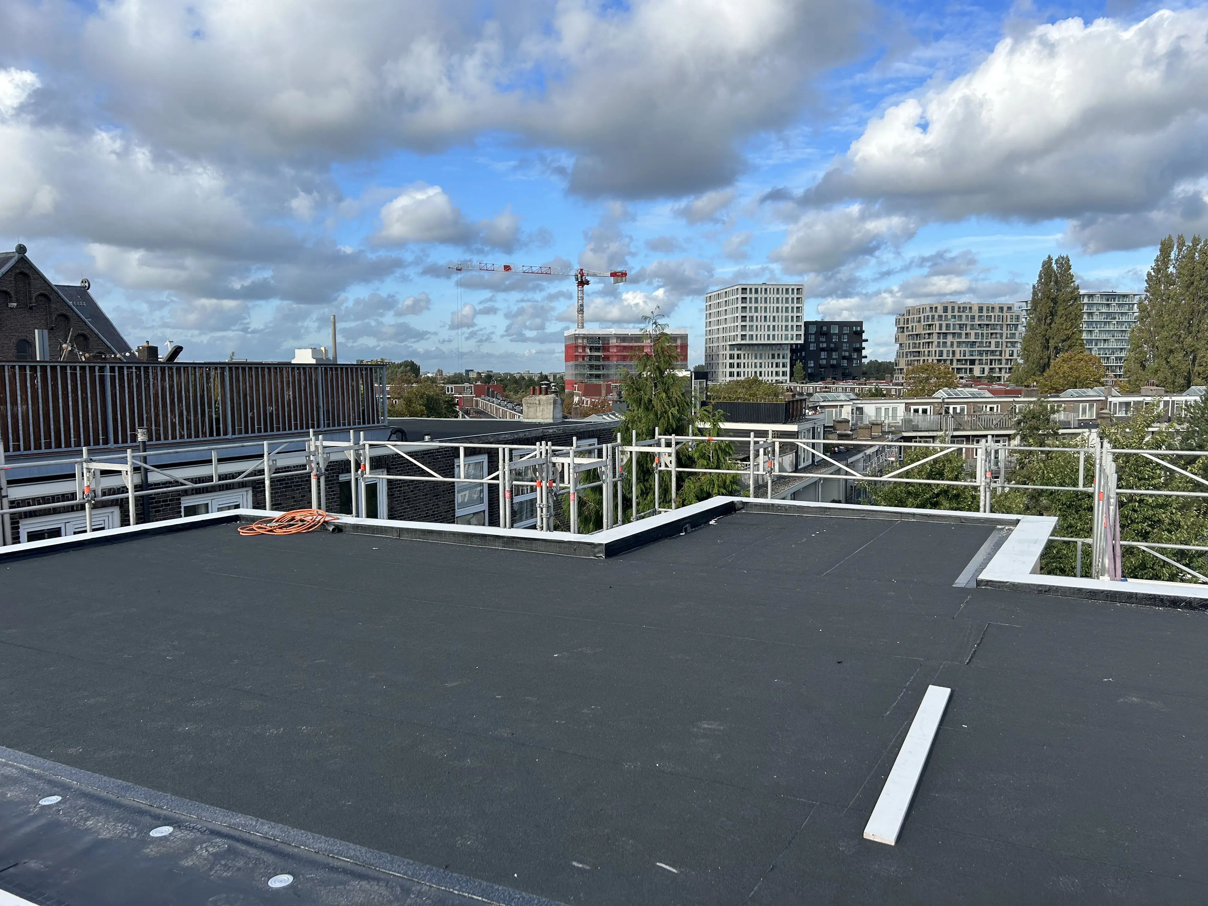 Dakdekkers van De Dakmannen brengen dakisolatie aan op een plat dak.