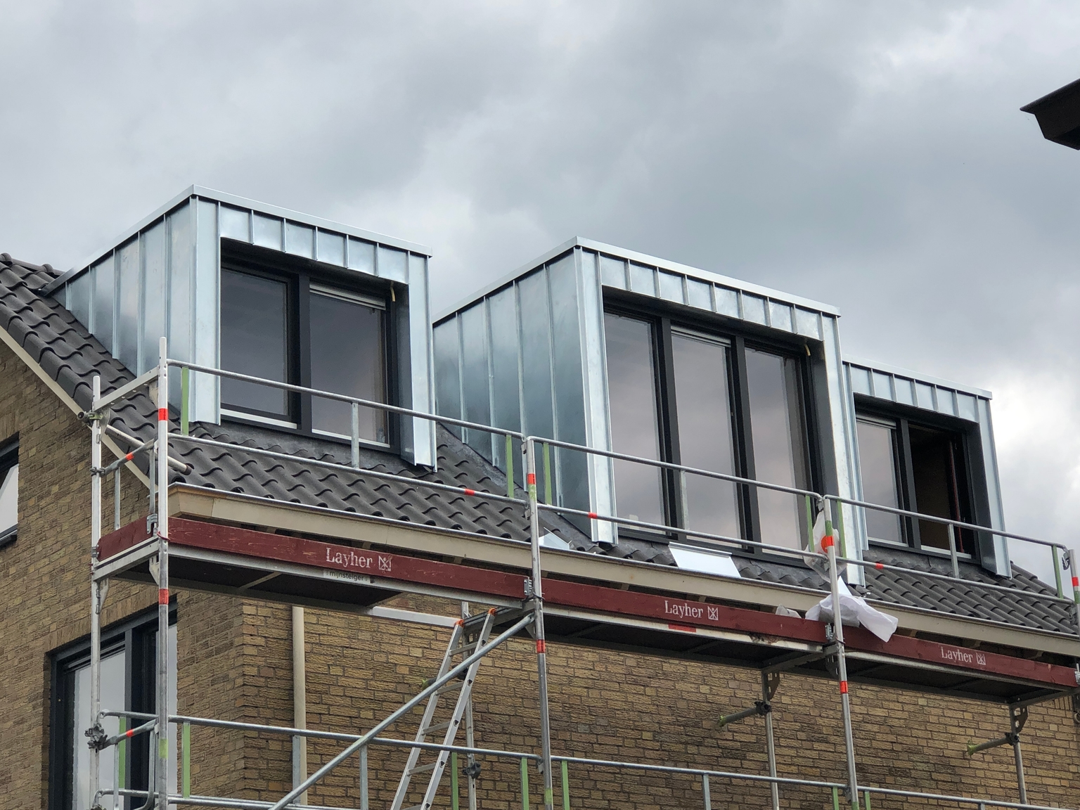 Specialist van De Dakmannen monteert nieuw zinkwerk en dakgoten bij een woning